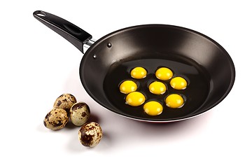 Image showing Whole and broken quail eggs in pan