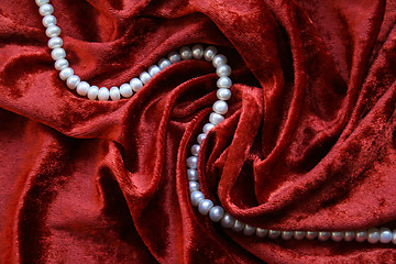 Image showing Necklace of white pearls on a terracotta velvet background 