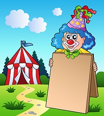 Image showing Clown holding board near tent