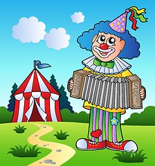 Image showing Clown playing accordion near tent