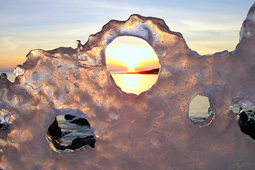 Image showing Sunset through ice's holes