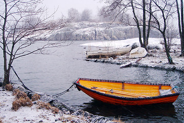 Image showing Orange fishing boat in winter in Finland