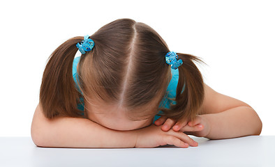 Image showing Little girl is sleeping at table