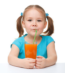 Image showing Little girl drinks orange juice