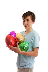 Image showing Excited boy holding foil wrapped chocolate easter eggs