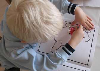 Image showing Three year old boy with his colouring book seen from above.