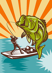 Image showing Largemouth Bass Fish jumping reeled by Fly Fisherman