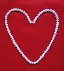 Image showing Heart from white pearls on a red silk for St Valentine's day 