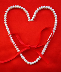 Image showing Heart from white pearls on a red silk for St Valentine's day 