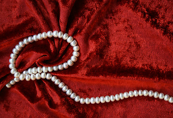 Image showing Necklace of white pearls on a terracotta velvet 