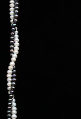 Image showing White and black pearls on the black velvet as background