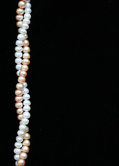 Image showing White and pink pearls on the black background