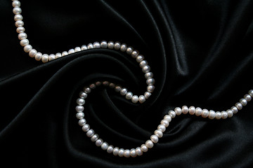 Image showing White pearls on the black silk 