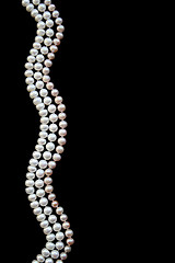 Image showing White and pink pearls on the black silk 