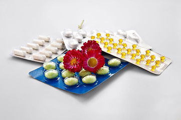 Image showing Tablets and capsules with daisies