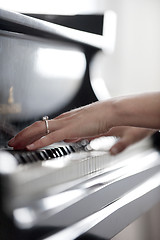 Image showing Close-up of girl's hands on piano