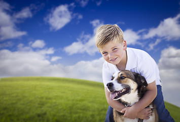 Image showing Handsome Young Boy Playing with His Dog in the Grass