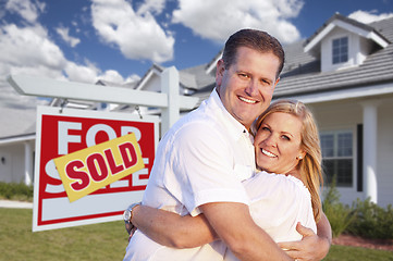 Image showing Couple Hugging in Front of Sold Sign and House