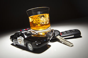 Image showing Highway Patrol Police Car Next to Alcoholic Drink and Keys