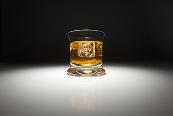 Image showing Glass of Whiskey and Ice Under Spot Light.