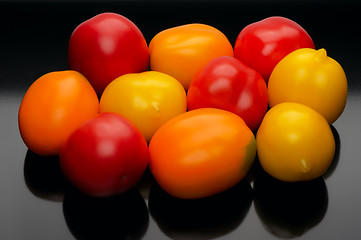 Image showing Multicolored tomatoes on a black backgrouns