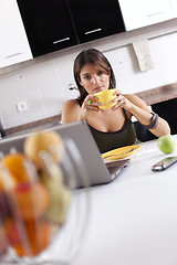 Image showing Modern woman reading e-mails at her breakfast