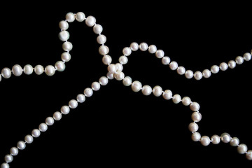 Image showing White pearls on the black silk as background 