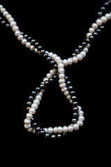 Image showing White and black pearls on a black velvet 