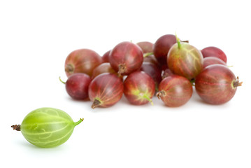 Image showing Pile of red gooseberries and one green near