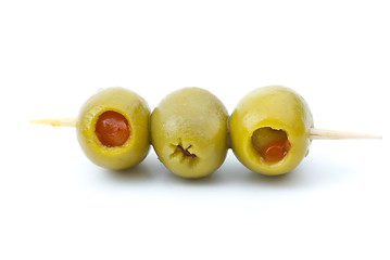 Image showing Some olives stuffed with pepper on a wooden toothpick