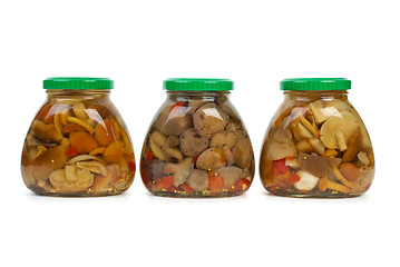 Image showing Three glass jars with marinated mushrooms