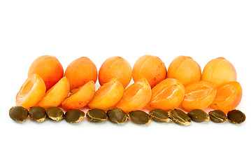 Image showing Few whole apricots and some halves with kernels 