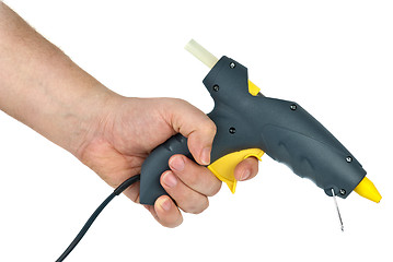 Image showing Hand holding glue gun