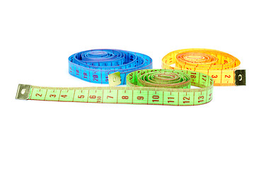 Image showing Three rolled measuring tapes of different colors