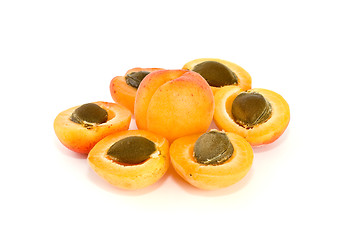 Image showing One whole and six apricot halves with kernels lying in form of flower