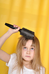 Image showing girl treying to brush her hair