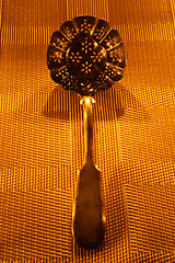 Image showing vintage silver serving spoon on candle lights