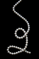 Image showing White pearls on the black velvet  background