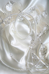 Image showing White pearls and nacreous beeds on white silk as wedding backgro