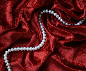 Image showing Necklace of white pearls on a terracotta velvet 