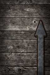 Image showing rusty arrow on wooden background