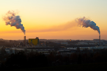 Image showing Sunrise silhouette of smoking factory