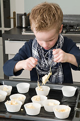 Image showing Kid Filling Cakecups With Dough