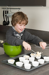 Image showing Kid Filling Cakecups With Dough