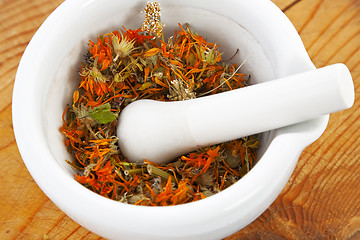 Image showing white mortar with dry marigold flower