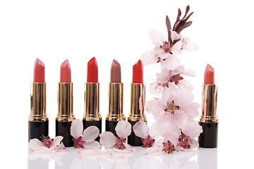 Image showing different red lipstick and cherry flower, beauty concept