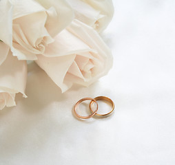 Image showing Wedding rings and roses as background 