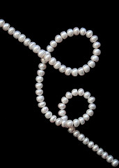 Image showing White pearls on the black silk 