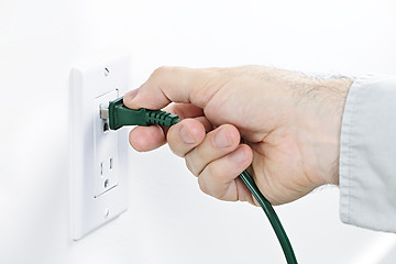 Image showing Hand inserting plug into outlet