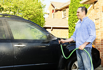 Image showing Man washing car on driveway